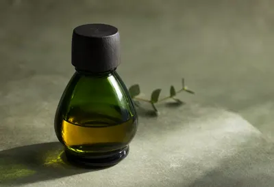 Dark Green Essential Oil Bottle with Botanical Shadows