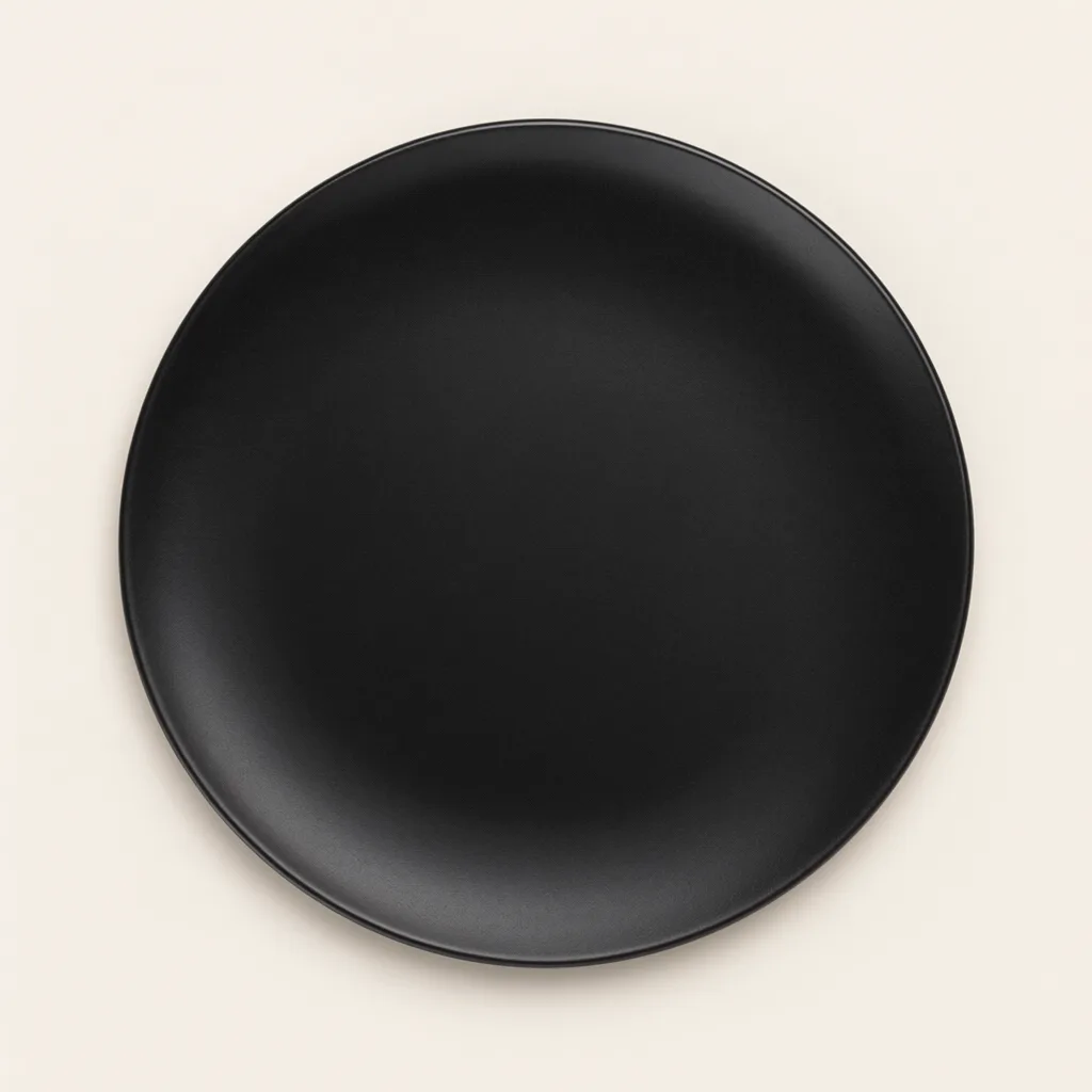 Black round plate viewed from above on an off-white background. (AI-generated)