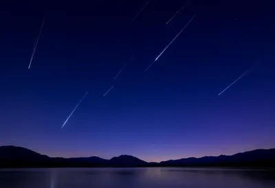 Shooting Stars Streaking Across a Deep Blue Night Sky (AI-generated)