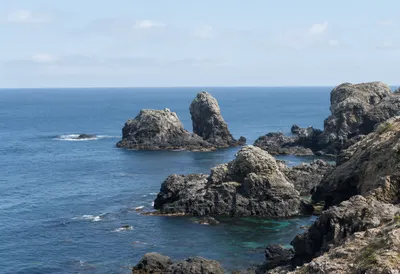 Rocky Ocean Coastline Under a Clear Blue Sky (AI-generated)