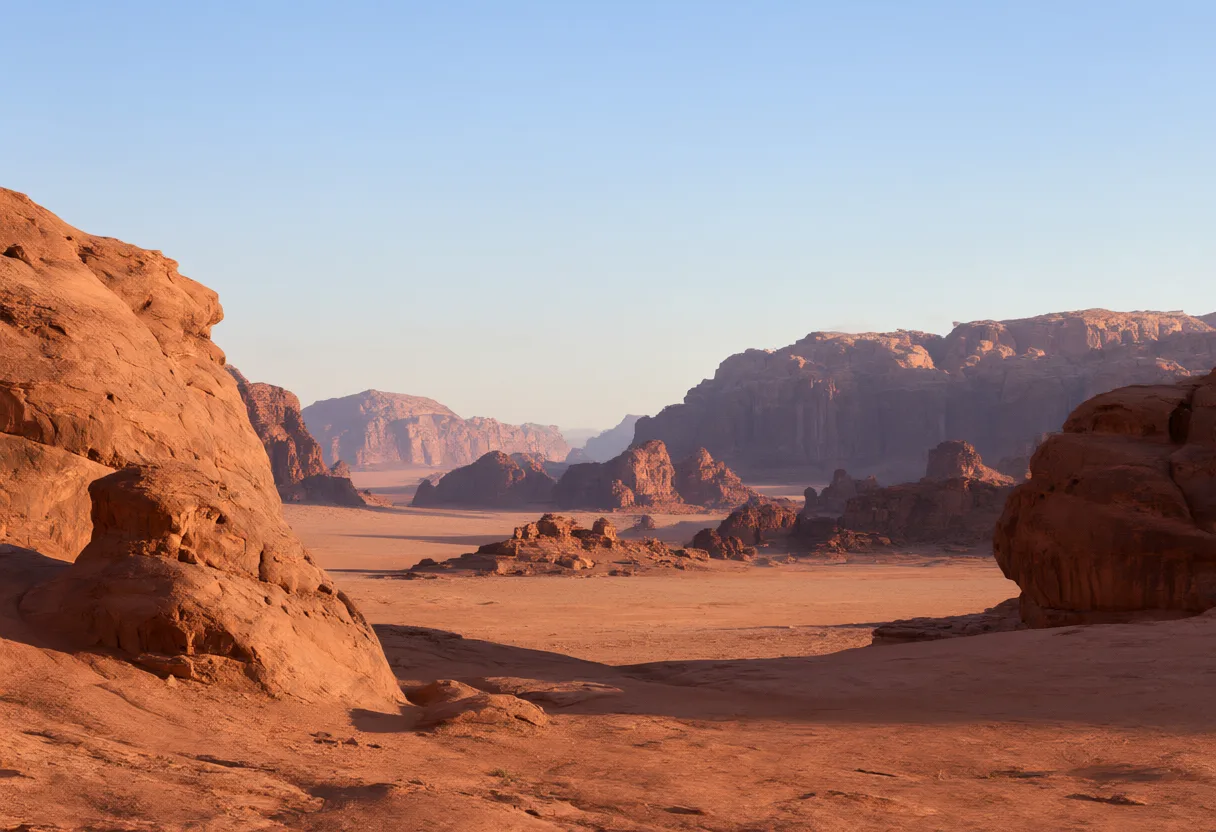 Red sandstone cliffs and rugged rock formations surround a wide desert valley in warm sunlight. (AI-generated)