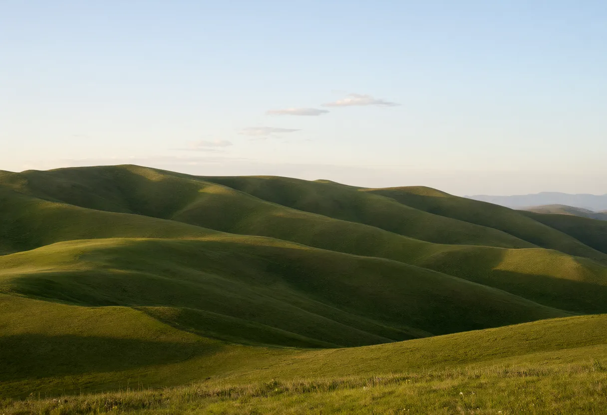Gentle rolling green hills extend across the countryside beneath a clear blue sky. (AI-generated)