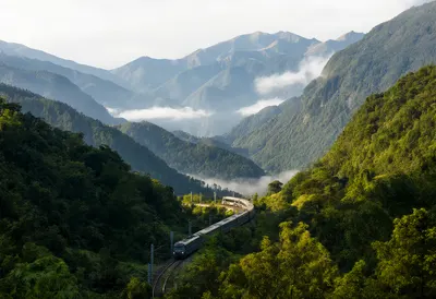 Scenic Train Traveling Through a Misty Green Mountain Valley (AI-generated)