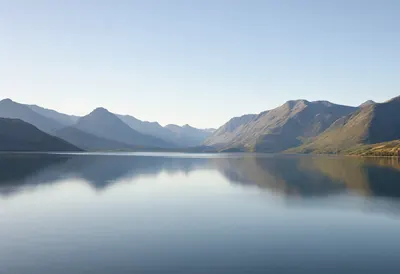 Peaceful Mountain Lake Reflecting the Blue Sky (AI-generated)