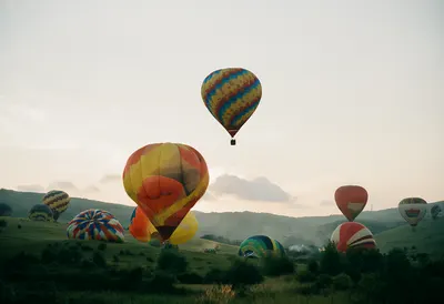 Hot Air Balloons over a Valley at Sunrise (AI-generated)