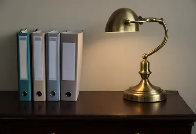 Stack of Folders and a Brass Desk Lamp