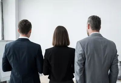 Team of Three from Behind at a Whiteboard
