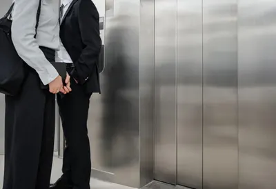Two Businesspeople in an Elevator Lobby