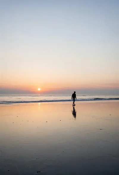 ซิลลูเตของวอล์คเกอร์บนชายหาดตอนพระอาทิตย์ตก