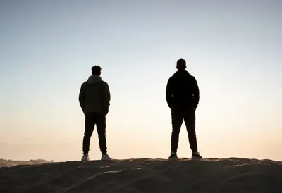 Two Friends on a Dune Ridge at Sunrise