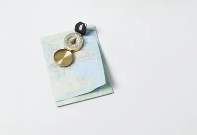 Folded Paper Map With A Brass Compass as a flat lay from above
