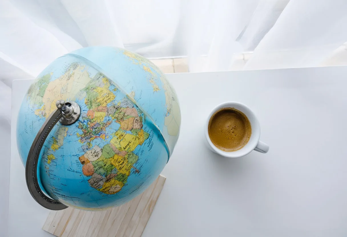 Globe และกาแฟหนึ่งแก้วที่หน้าต่างโดยวางแบนจากด้านบน