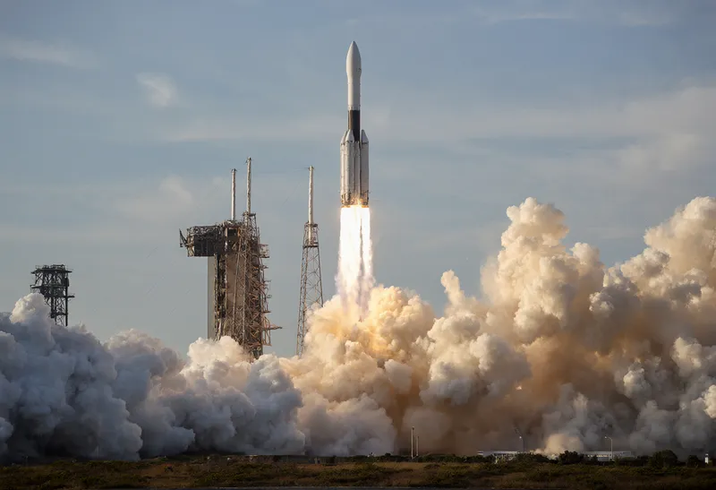 Rocket launching from a coastal facility with vast clouds of exhaust smoke