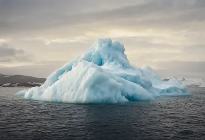 Iceberg Floating in Calm Water at Dusk