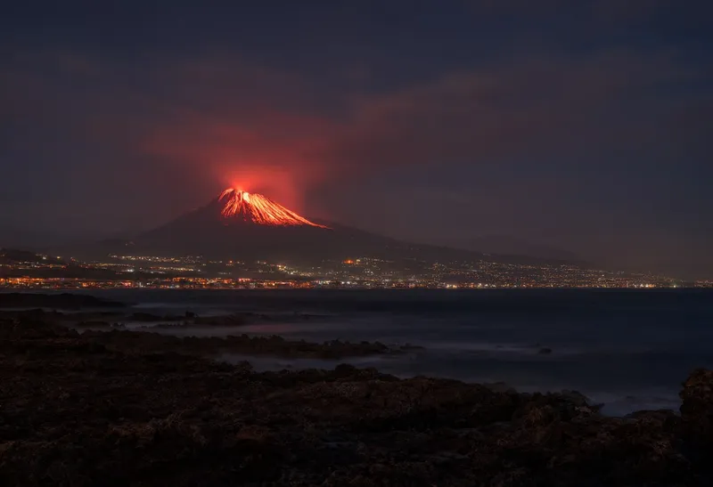 Volcanic Lava Glow behind a City at Night