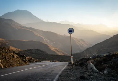Mountain Pass With A Lonely Road Sign at sunrise