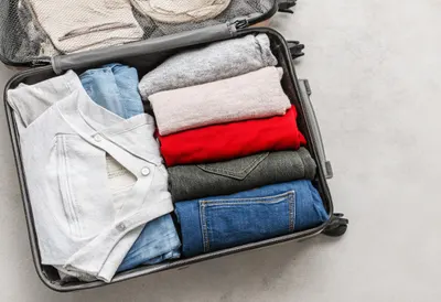 Open Suitcase With Neatly Folded Clothes as a flat lay from above