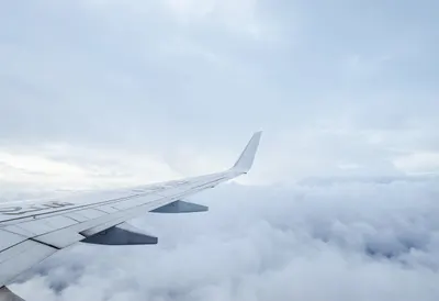 Airplane Wing Above A Sea Of Clouds in the rain