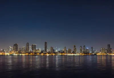 City Lights Skyline Across Calm Water At Night