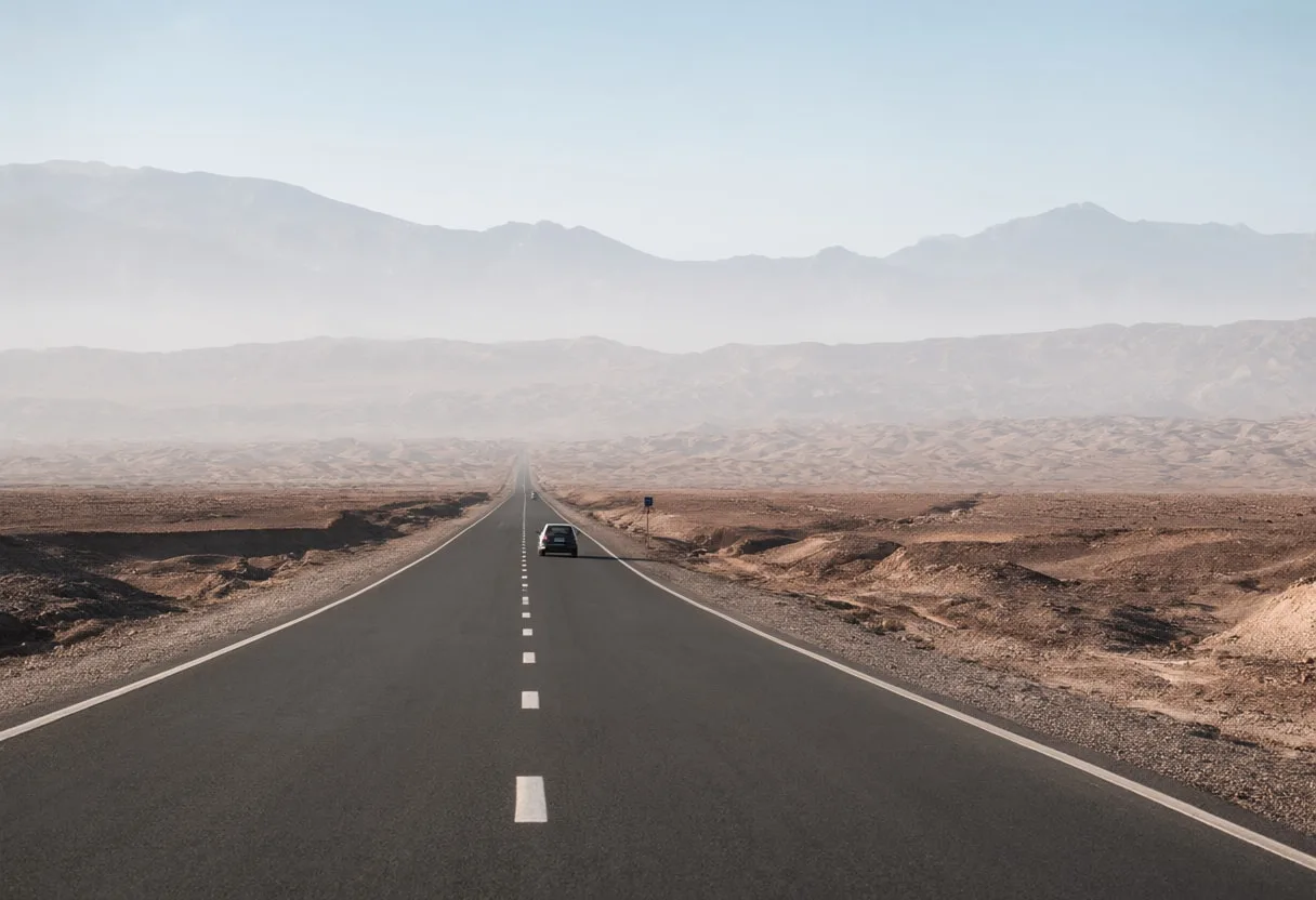 Desert Road With A Single Car Far Away in soft mist