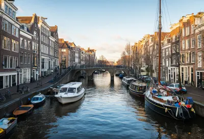 Canal Town With A Bridge And Moored Boats in warm evening light