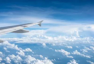 Airplane Wing Above A Sea Of Clouds under a dramatic sky Digital Illustration