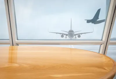 Airport Window With An Airplane Silhouette on a warm wooden table