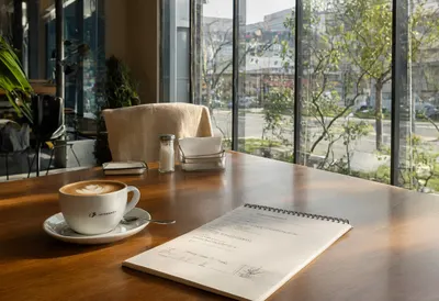 Coffee and report with warm window light, wide angle