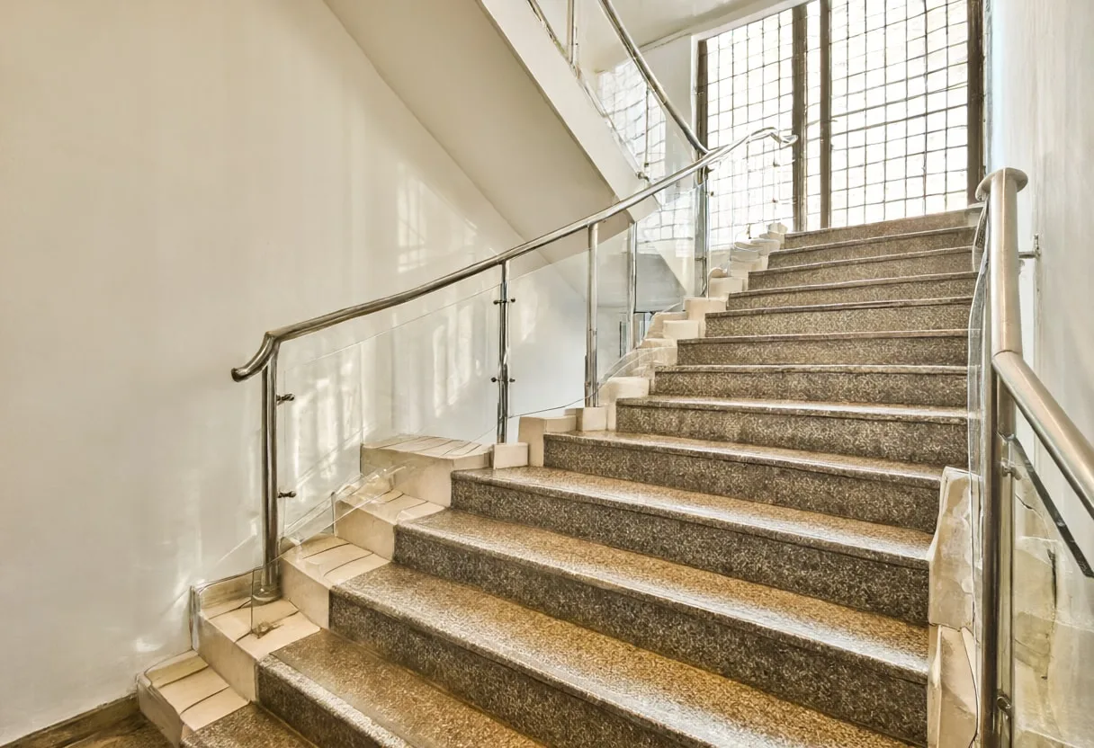 Lobby staircase with warm window light, low angle
