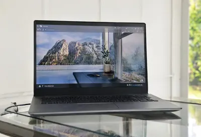 Laptop on glass desk under natural daylight, wide angle