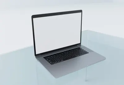 Laptop on glass desk in a clean studio, high angle